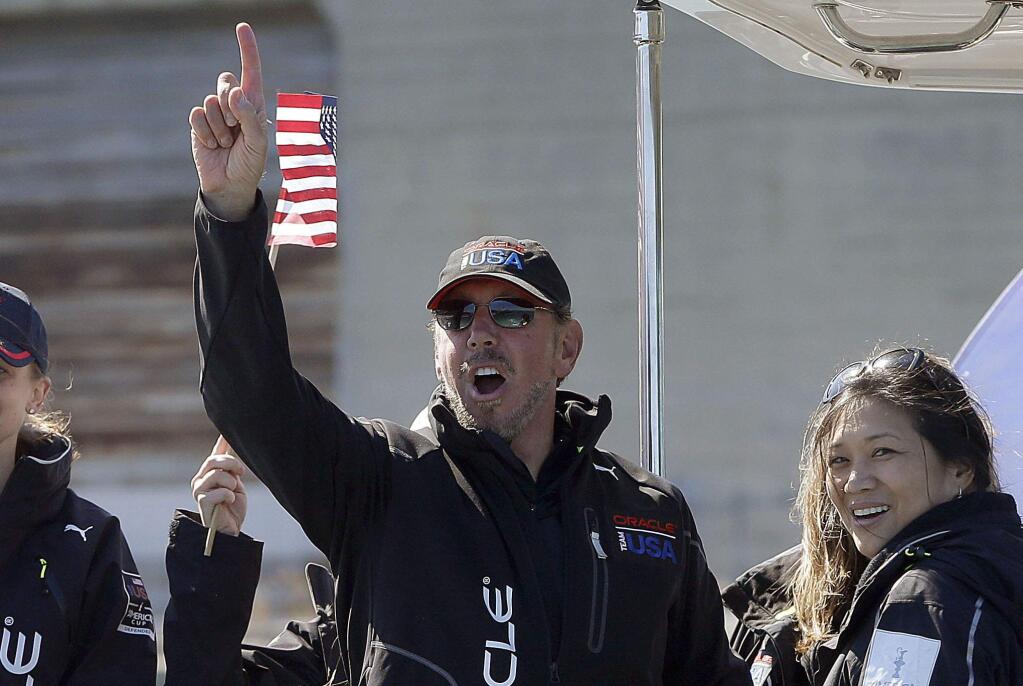 In this Sept. 24, 2013, file photo, Oracle CEO Larry Ellison, center, gestures after Oracle Team USA won the 18th race of the America's Cup sailing event against Emirates Team New Zealand, in San Francisco. (AP Photo/Ben Margot, File)