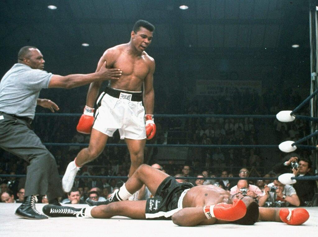 In this May 25, 1965 file photo, heavyweight champion Muhammad Ali is held back by referee Joe Walcott after Ali dropped challenger Sonny Liston less than two minutes into the first round of their heavyweight title fight, in Lewiston, Maine. On today's' 50th anniversary of the fight, it remains one of the most controversial sporting events of the 20th century. (Associated Press)