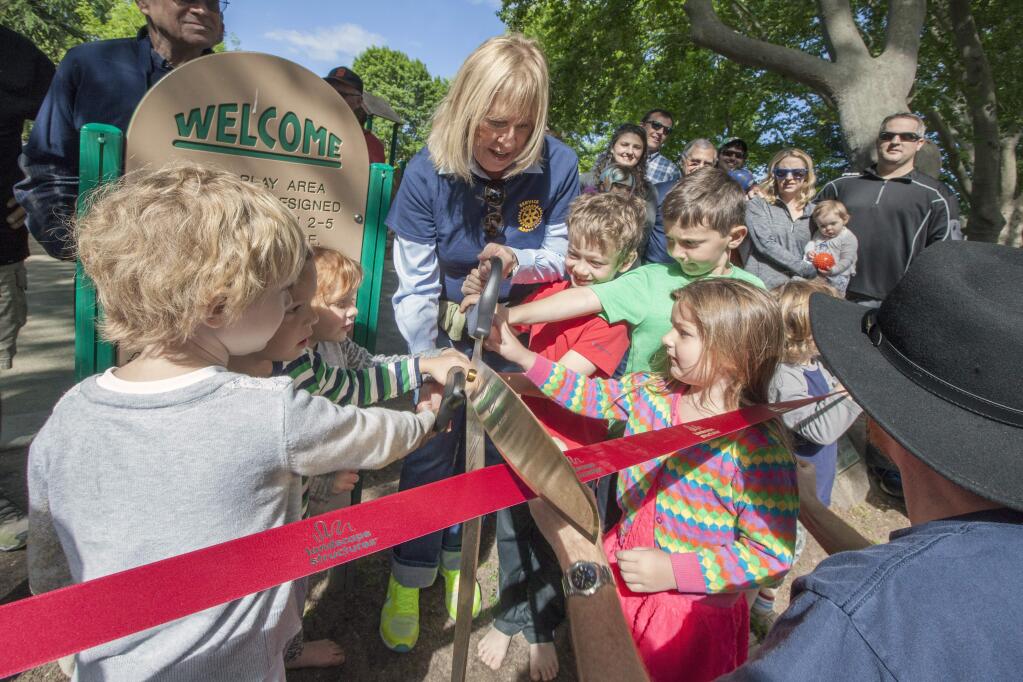 Susan Kopp Hoeffel, president of the Rotary of Sonoma Valley, keeps little hands safe as they assisted with the official ribbon cutting. A group of Sonoma Valley Rotarians gathered at the children's playground on Sonoma Plaza last Sunday, April 24, to commemorate the club's 70th anniversary of its charter date. Two plaques were installed (one for the 1950 construction of the playground and the other for its 2015 refurbishment). (Photos by Robbi Pengelly/Index-Tribune)