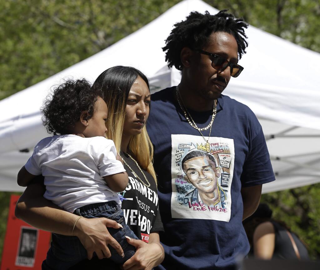 Salena Manni, the fiancee of police shooting victim Stephon Clark, holds the couple's son, Aiden as she and Clark's uncle, Curtis Gordon attend a rally aimed at ensuring Clark's memory and calling for police reform, Saturday, March 31, 2018, in Sacramento, Calif. The gathering comes nearly two weeks after Clark, who was unarmed, was shot and killed by two Sacramento police officers. (AP Photo/Rich Pedroncelli)