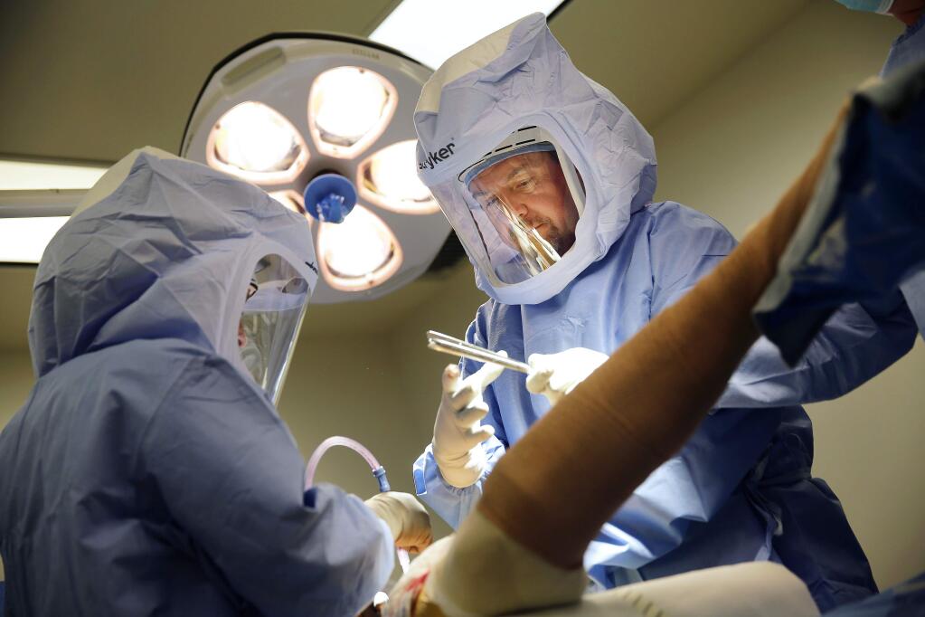 Orthopedic surgeon Kevin Howe, MD, performs a hip replacement surgery on Lee Olibas at Santa Rosa Memorial Hospital on Friday, July 18, 2014. (Conner Jay/The Press Democrat)