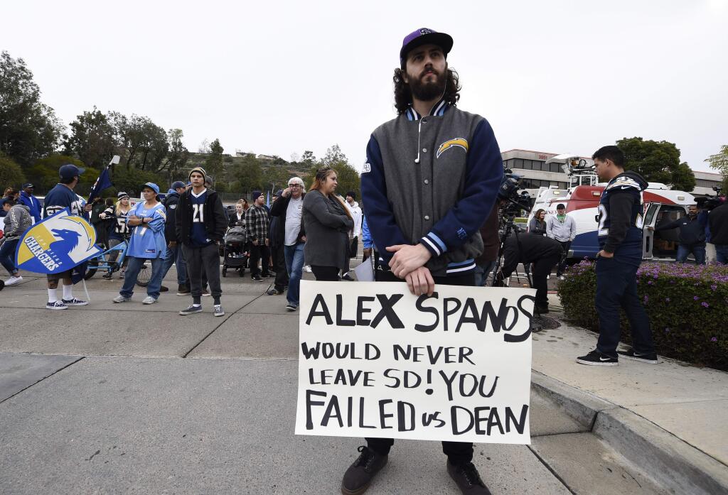 Joseph Macrae holds up a sign in front of of the San Diego Chargers headquarters after the team announced that it will move to Los Angeles, Thursday Jan. 12, 2017, in San Diego. (AP Photo/Denis Poroy)