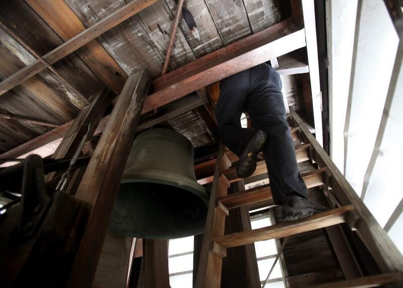 John Roche enters the top of the clock tower in Empire Building on Courthouse Square past the bell forged in 1908. (John Burgess/The Press Democrat)