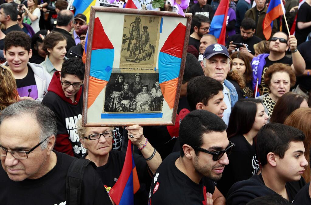 Demonstrators carrying signs and Armenian flags march in Los Angeles Friday, April 24, 2015, to commemorate the 100th anniversary of the killings of an estimated 1.5 million Armenians during the Ottoman Empire rule over Turkey, and to press for recognition by Turkey and the U.S. that the killings should be considered genocide. (AP Photo/Nick Ut)