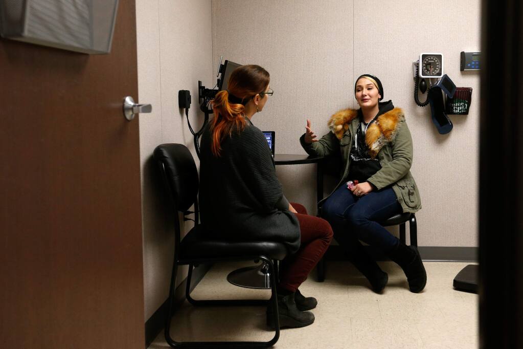Alicia Tighe, right, talks with Dr. DeEtte DeVille during a checkup at Russian River Health Center in Guerneville, California on Friday, January 6, 2017. Medi-Cal patients may lose their health coverage if portions of the Affordable Care Act are repealed. (Alvin Jornada / The Press Democrat)