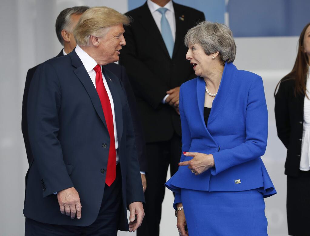President Donald Trump, left, talks with British Prime Minister Theresa May, right, during a family photo at a summit of heads of state and government at NATO headquarters in Brussels on Wednesday, July 11, 2018. NATO leaders gather in Brussels for a two-day summit to discuss Russia, Iraq and their mission in Afghanistan. (AP Photo/Pablo Martinez Monsivais)