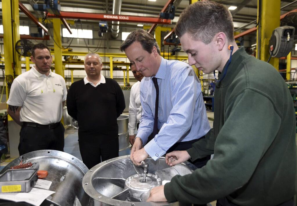 British Prime Minister David Cameron helps build an industrial fan during a campaign visit in Colchester last month. (TOBY MELVILLE, pool / Associated Press)