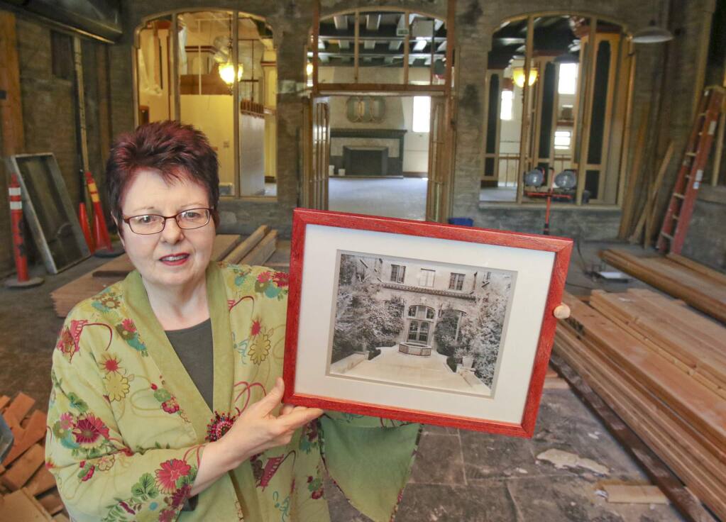 Juli Lederhaus, General Manager of Hotel Petaluma stands in what was once the entry courtyard of the hotel, as seen in the photo she is holdeing but was turned into an indoor space for years including being ocupied by Taps bar in recent years, on Tuesday May 26, 2015. (SCOTT MANCHESTER/ARGUS-COURIER STAFF)