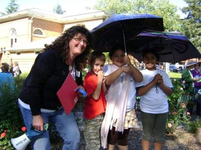 Barbara Cullen with children for an event that she organized in the Plaza where each child painted an umbrella.