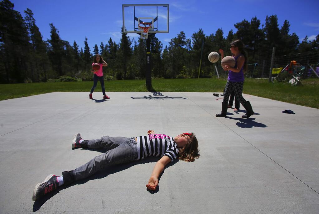 Quen Ballard spins a fidget spinner on her forehead while her classmates shoot baskets at Albion Elementary School, in Albion, on Thursday, May 18, 2017. (Christopher Chung/ The Press Democrat)