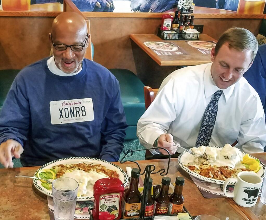 In this photo provided by California Innocence Project Horace Roberts, left, has his first meal after walking out of Avenal State Prison with California Innocence Project managing attorney Michael Semanchik in Avenal, Calif., Oct. 3, 2018. Roberts, wrongly convicted of murdering his lover two decades ago has been exonerated and new arrests have been made in the case. (California Innocence Project via AP)