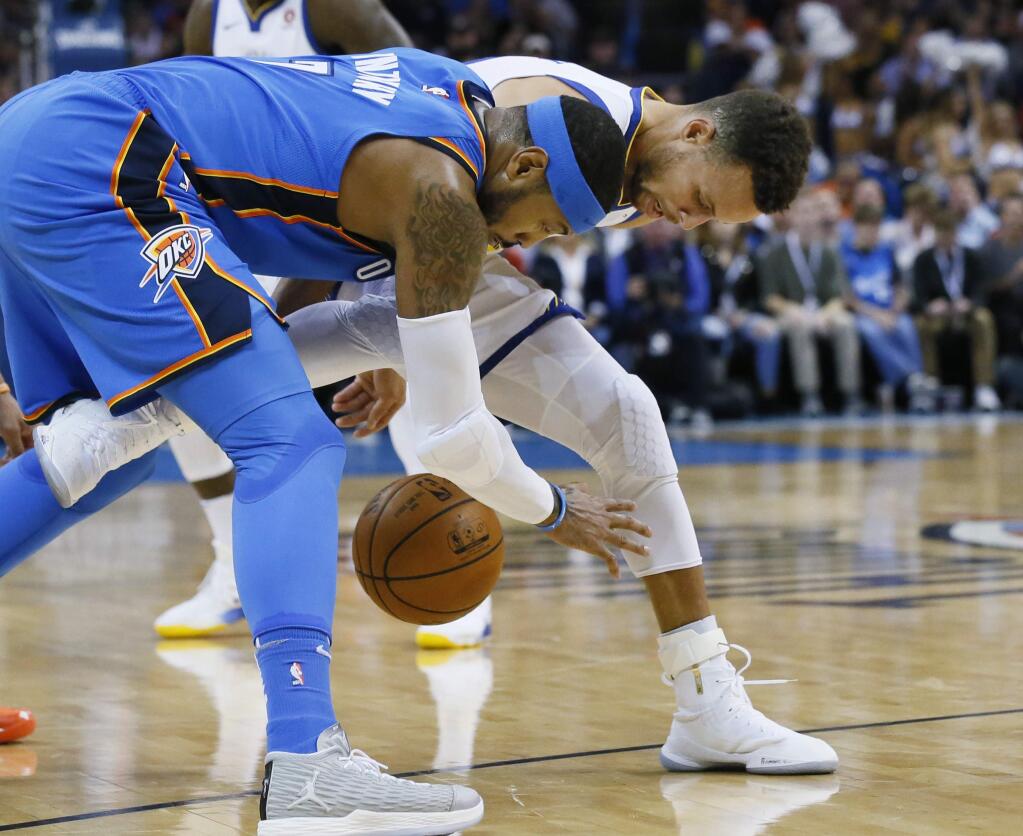 Oklahoma City Thunder forward Carmelo Anthony, left, steals the ball from Golden State Warriors guard Stephen Curry during the first quarter of an NBA basketball game in Oklahoma City, Wednesday, Nov. 22, 2017. (AP Photo/Sue Ogrocki)