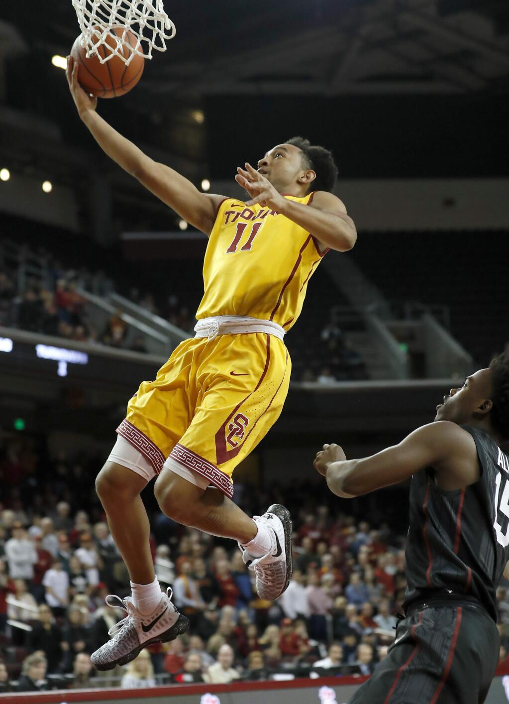 Southern California's Jordan McLaughlin, left, goes to the basket next to Stanford's Marcus Allen, right, during the first half of an NCAA college basketball game Thursday, Jan. 5, 2017, in Los Angeles. (AP Photo/Ryan Kang)