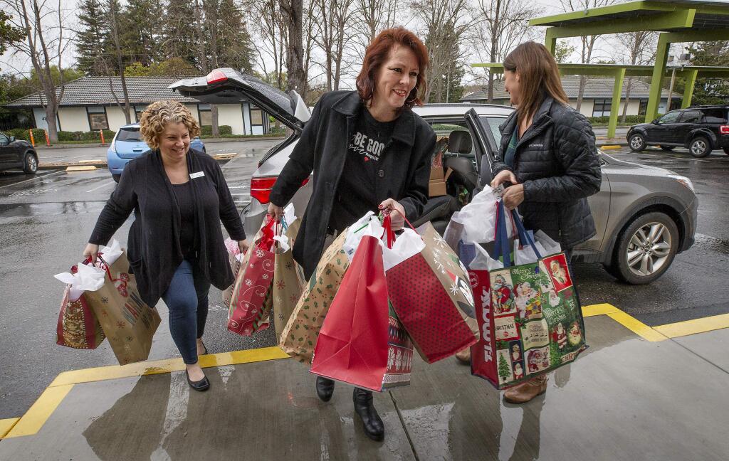 Krista Gawronski, the organizer of 'The Fabulous Women's Group' in Petaluma, center, drops off blankets, clothing and gift cards at Social Advocates for Youth in Santa Rosa with Glenara Kindred, right, and SAY CEO Katrina Thurman. (photo by John Burgess/The Press Democrat)