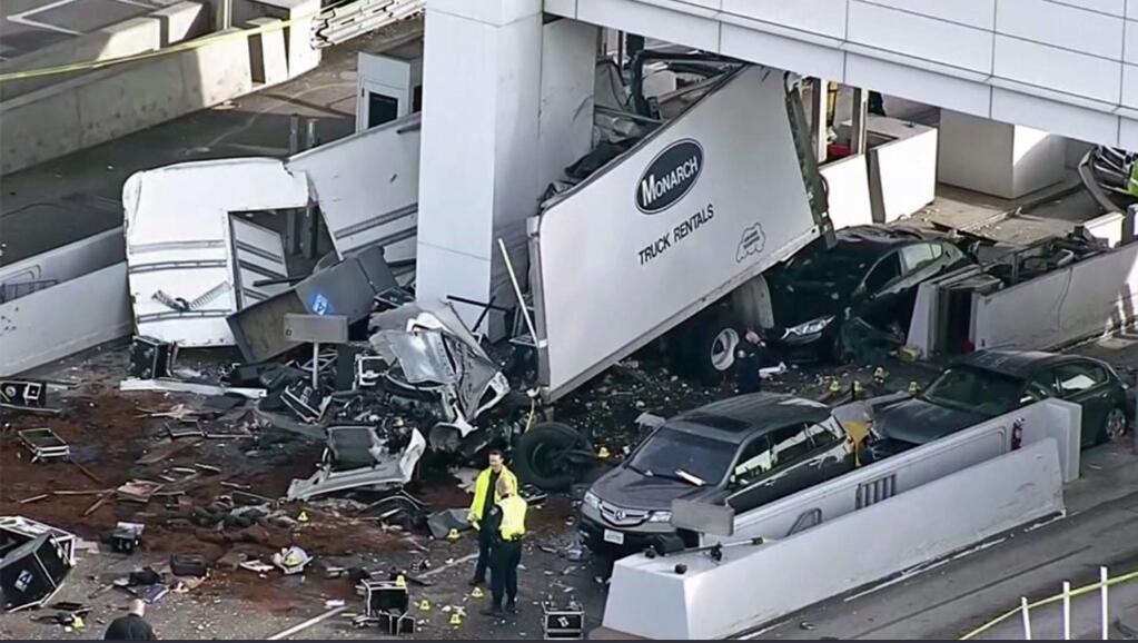 This still frame from video provided by KPIX-TV shows a large box truck that crashed into a toll booth on the San Francisco-Oakland Bay Bridge in Oakland, Calif., Saturday, Dec. 2, 2017. California Highway Patrol Officer Vu Williams said the box truck struck several vehicles and then hit a toll both, killing the attendant inside. The truck driver and a passenger were ejected from the vehicle, suffering serious injuries. (KPIX-TV via AP)
