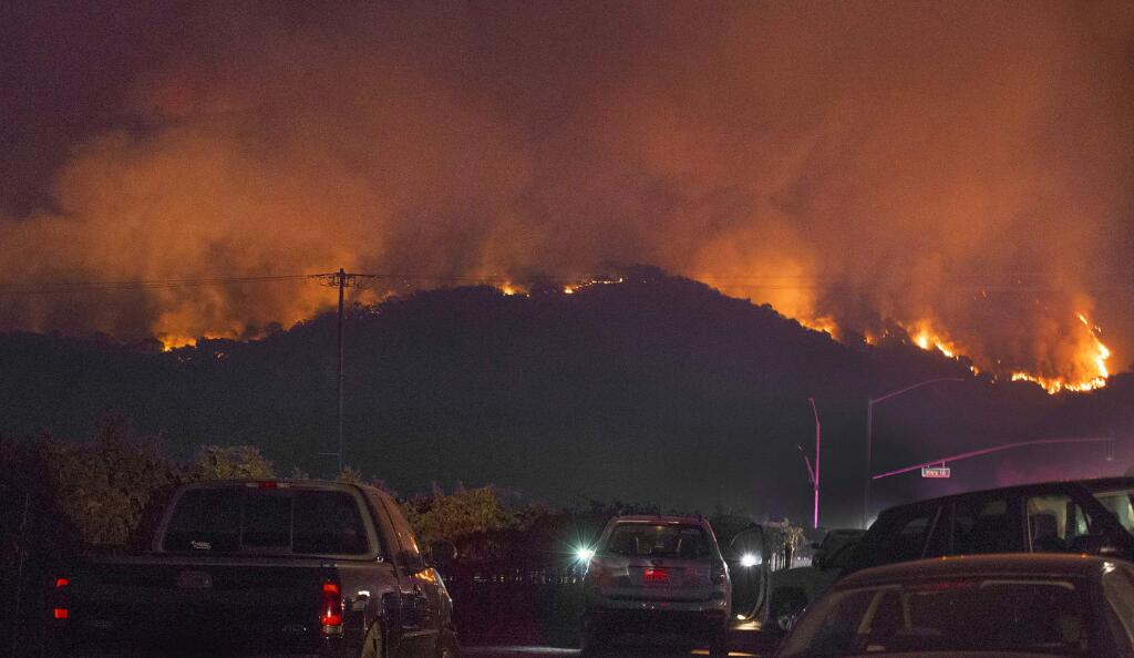 On Tuesday evening, locals gathered in the hundreds to watch plumes of smoke from the fire in the hills behind the intersection of Highway 12 and Madrone Road. (Photo by Robbi Pengelly/Index-Tribune)