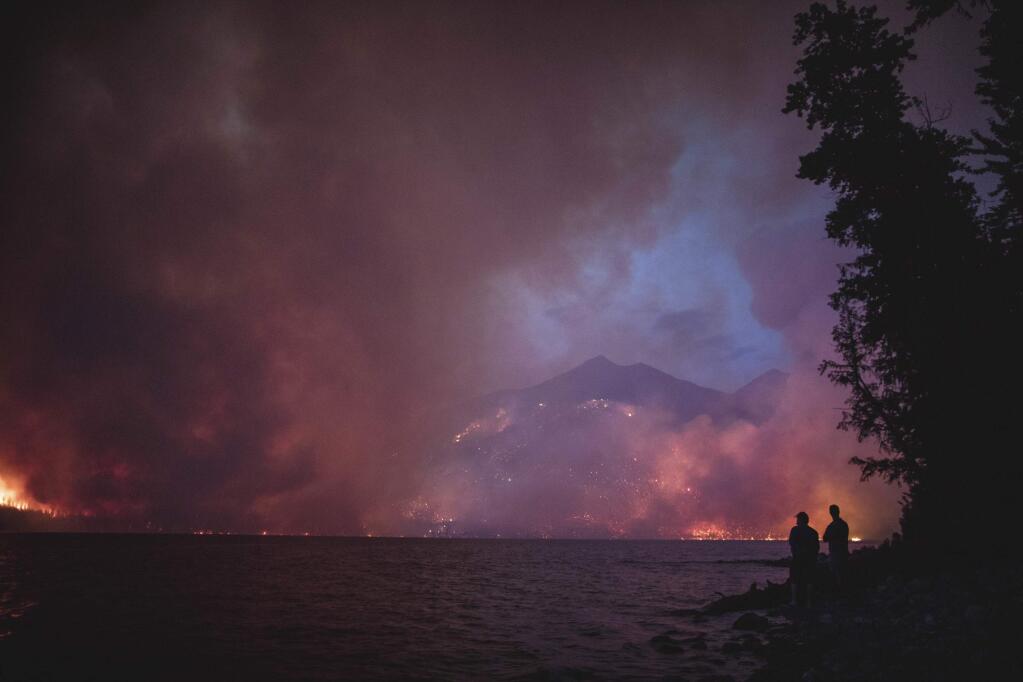 FILE - This Sunday, Aug. 12, 2018 file photo provided by the National Park Service shows the Howe Ridge Fire from across Lake McDonald in Glacier National Park, Mont. The wildfire in northwest Montana's Glacier National Park is forcing evacuations and has burned within a mile of the scenic Going-to-the-Sun Road. The Missoulian reported Sunday, Aug. 19, 2018 that the Howe Ridge fire had grown to more than 12 square miles, and shifting winds are forecast over the next day and a half. (National Park Service via AP, File)