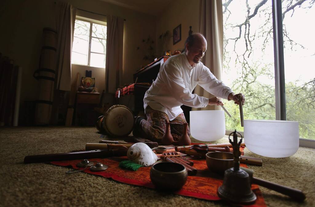 Musician Rene Jenkins demonstrates the use of crystal bowls to create therapeutic sounds at his home in Sonoma, on Thursday, March 10, 2016. (Christopher Chung/ The Press Democrat)