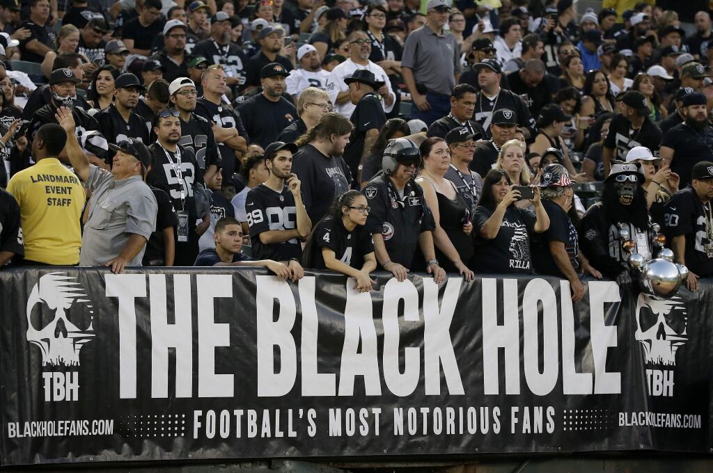 FILE - In this Aug. 31, 2017, file photo, Oakland Raiders fans watch from the Black Hole section of Oakland Alameda County Coliseum during the first half of an NFL preseason football game between the Raiders and the Seattle Seahawks in Oakland, Calif. The slow, agonizing demise of the Oakland Raiders will continue for at least one more season. There will be one more 'final' home game at the Oakland Coliseum, Dec. 15 against the Jacksonville Jaguars. There have been possible 'final' home games for a few years now because the Raiders have essentially had one foot out the door since 2015, when they joined with the AFC West rival Chargers in a failed attempt to build a stadium in the Los Angeles suburb of Carson. (AP Photo/Eric Risberg, File)