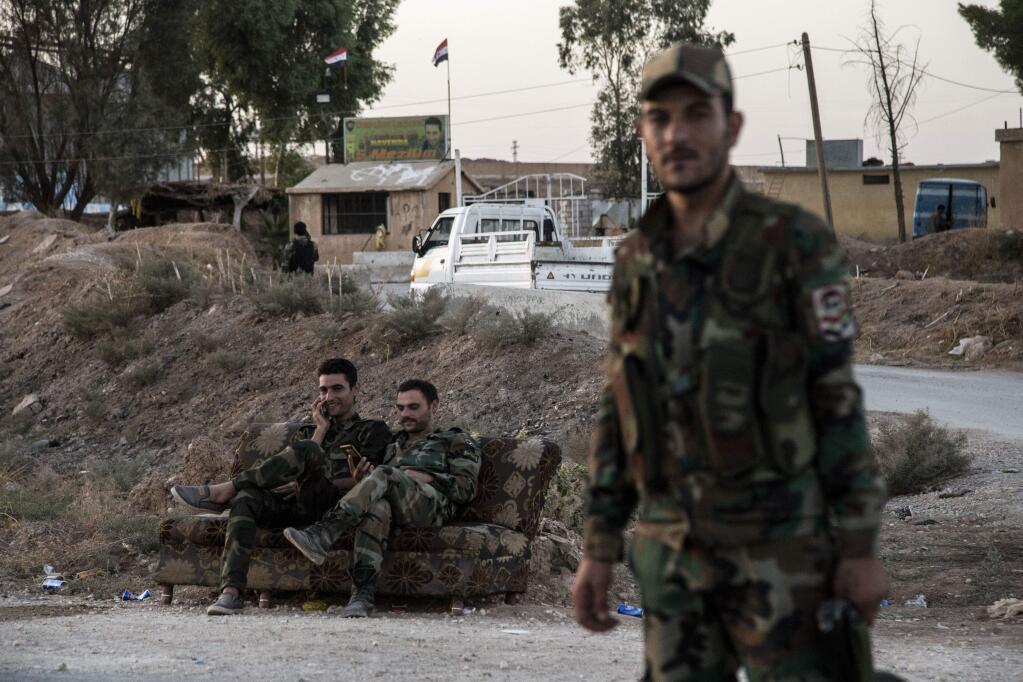 Syrian government troops man a checkpoint town of Tal Tamr in northeast Syria, Monday, Oct. 14, 2019. Syrian government troops moved into towns and villages in northern Syria on Monday, setting up a potential clash with Turkish-led forces advancing in the area as long-standing alliances in the region begin to shift or crumble following the pullback of U.S. forces. (AP Photo/Baderkhan Ahmad)