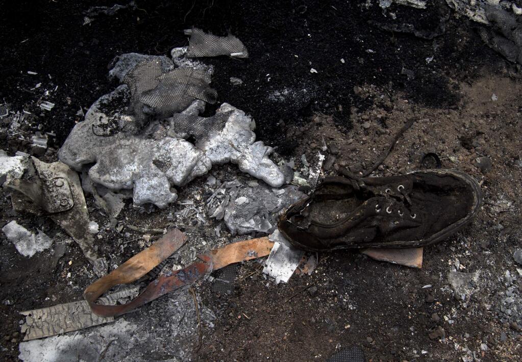 A shoe lies next to melted aluminum at the crash site of Malaysia Airlines Flight 17 near the village of Hrabove, eastern Ukraine, Tuesday, July 22, 2014. (AP Photo/Vadim Ghirda)