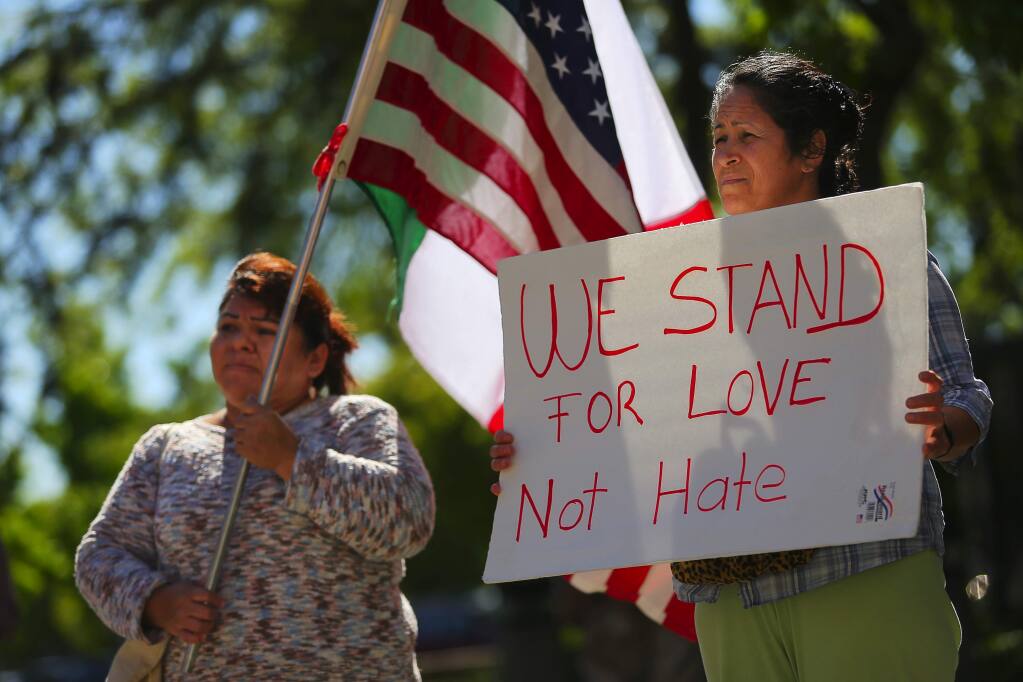 Ana Salgado, left, and Patricia, who declined to provide her last name, participate in an immigration demonstration at the Sonoma County Main Adult Detention Facility, to protest the Sonoma County Sheriff's Office sharing of information of undocumented inmates with the U.S. Immigration and Customs Enforcement, in Santa Rosa on Monday, May 1, 2017. (Christopher Chung/ The Press Democrat)