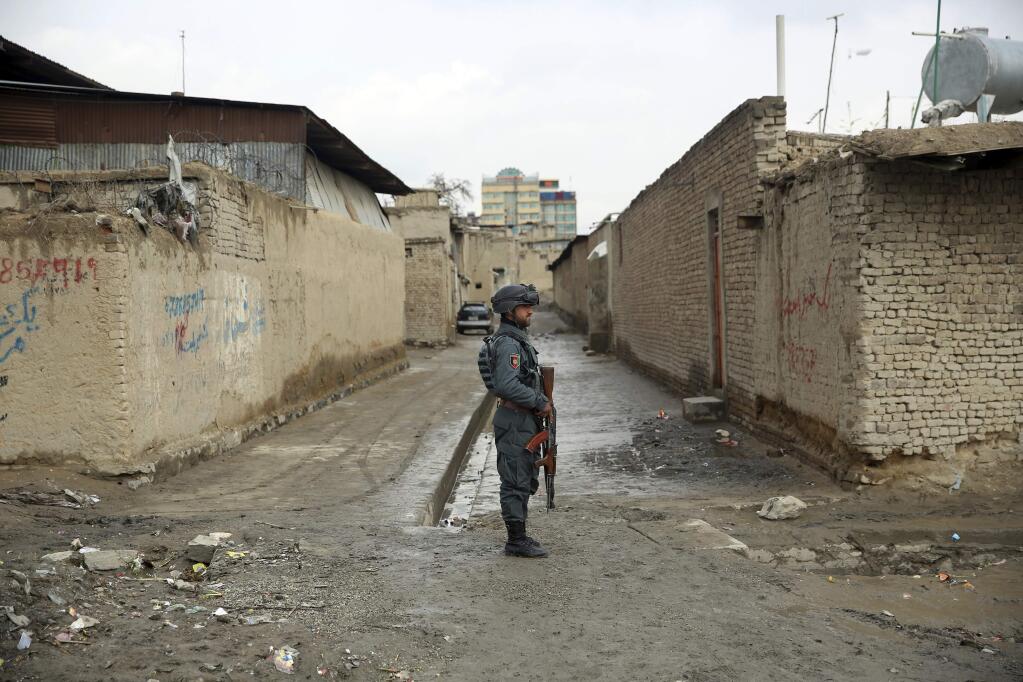 An Afghan security guard stands at the site of an attack in Kabul, Afghanistan, Wednesday, March 25, 2020. Gunmen stormed a religious gathering of Afghanistan's minority Sikhs in their place of worship in the heart of the Afghan capital's old city on Wednesday, a minority Sikh parliamentarian said. (AP Photo/Rahmat Gul)