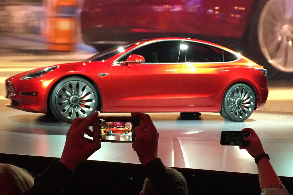 FILE- In this March 31, 2016, file photo, Tesla Motors unveils the new lower-priced Model 3 sedan at the Tesla Motors design studio in Hawthorne, Calif. (AP Photo/Justin Pritchard, File)