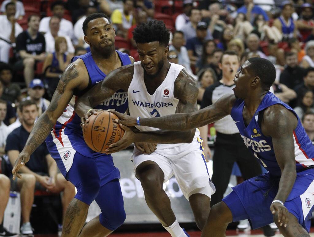 In this July 6, 2018 file photo, the Golden State Warriors' Jordan Bell, center, drives between the Los Angeles Clippers' Sindarius Thornwell, left, and Jawun Evans during the first half of a summer league game in Las Vegas. (AP Photo/John Locher, File)