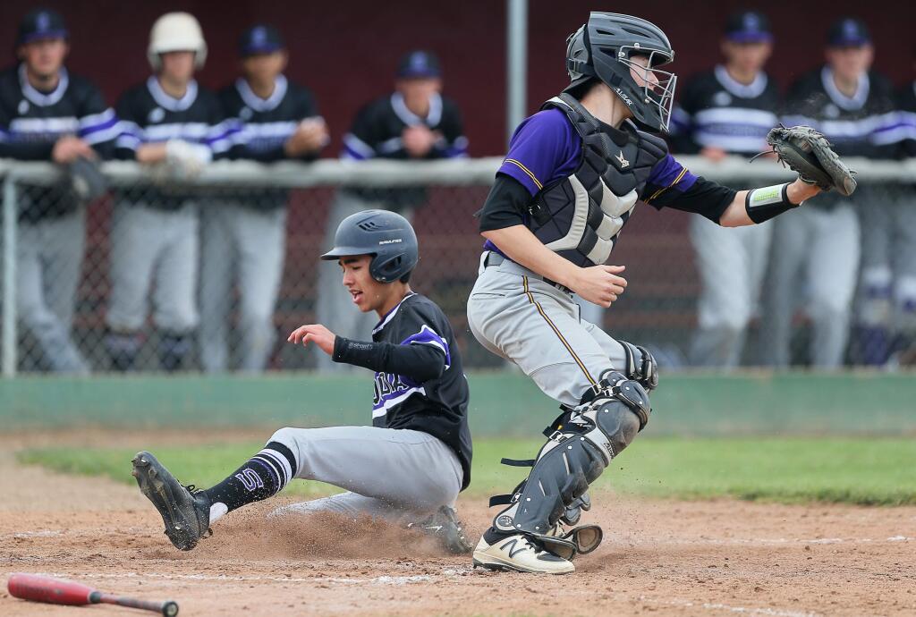 Sequoia's Nolan Doyle scores as Ukiah catcher Justin Lucas gets the ball too late during the A.L. Rabinovitz tournament in Santa Rosa on Tuesday, March 19, 2019. (Christopher Chung / The Press Democrat)