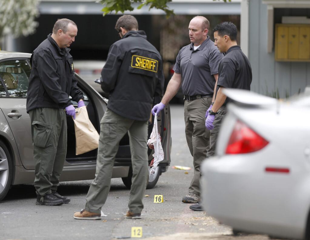 Sonoma County sheriff deputies and detectives collect evidence from a shooting near a Corby Avenue apartment complex in Santa Rosa on July 6, 2015. (BETH SCHLANKER/ PD)