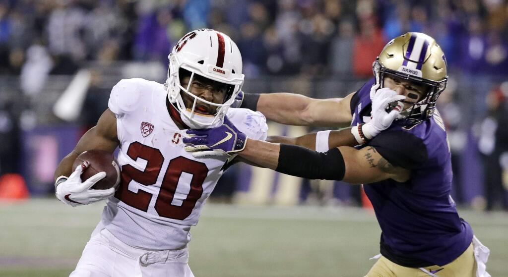 Stanford's Bryce Love pushes back on Washington's Taylor Rapp on a carry during the second half on Saturday, Nov. 3, 2018, in Seattle. Rapp was called for a horse-collar tackle on the play. Washington won 27-23. (AP Photo/Elaine Thompson)