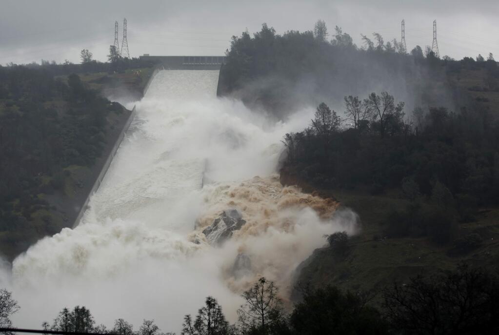 Water flows through break in the wall of the Oroville Dam spillway, Thursday, Feb. 9, 2017, in Oroville, Calif. The torrent chewed up trees and soil alongside the concrete spillway before rejoining the main channel below. Engineers don't know what caused what state Department of Water Resources spokesman Eric See called a 'massive' cave-in that is expected to keep growing until it reaches bedrock. (AP Photo/Rich Pedroncelli)