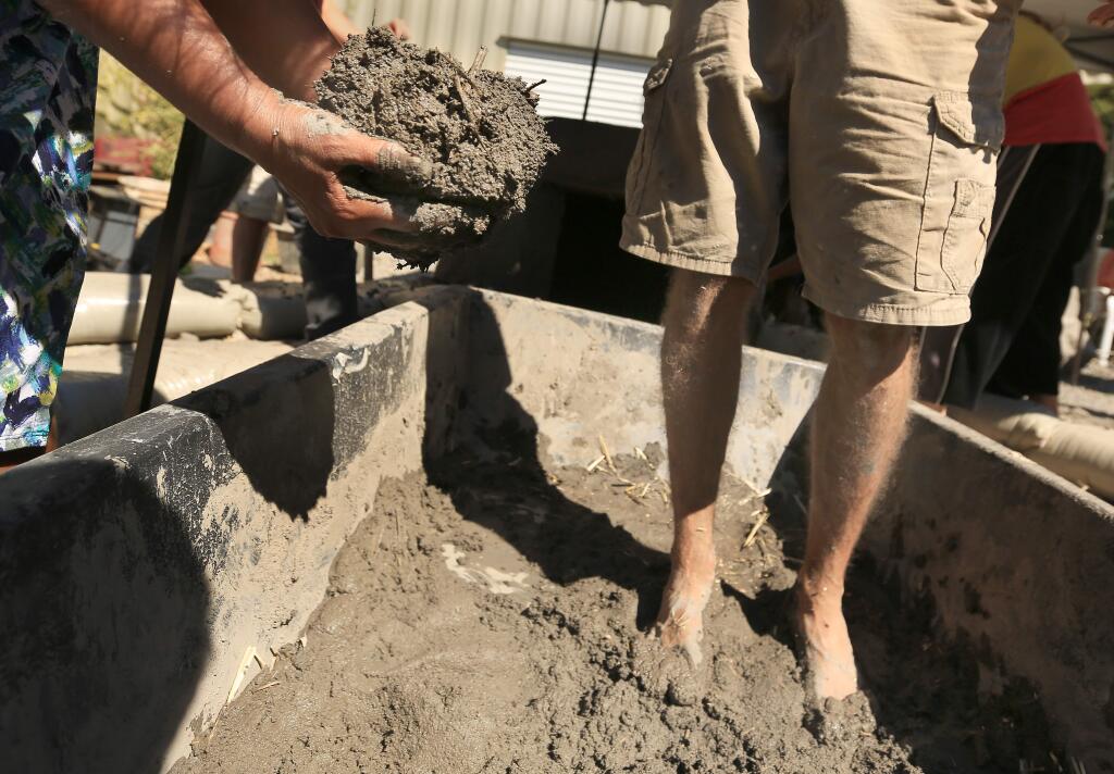 Volunteers construct a pizza oven from sand, water, dirt and hay at Hardcore Coffee in Sebastopol on Friday, Sept. 12, 2014. (KENT PORTER/ PD)