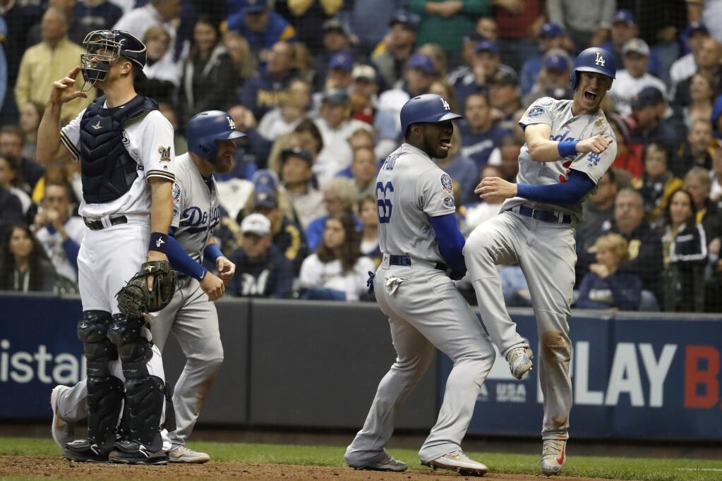 The Los Angeles Dodgers' Yasiel Puig (66) celebrates with Cody Bellinger (35) and Max Muncy (13) after hitting a three-run home run during the sixth inning of Game 7 of the National League Championship Series against the Milwaukee Brewers Saturday, Oct. 20, 2018, in Milwaukee. (AP Photo/Jeff Roberson)
