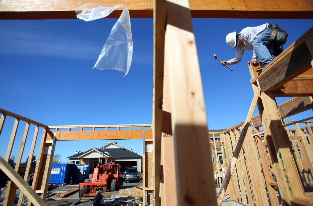 Chris Tuxhorn works on a new home at the Country Meadow subdivision in Santa Rosa. (CHRISTOPHER CHUNG / The Press Democrat, 2014)