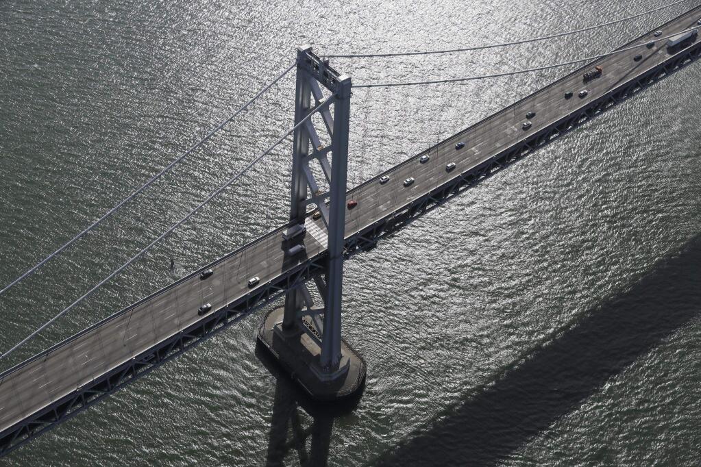 FILE - In this Feb. 5, 2016, file photo, the western section of the San Francisco-Oakland Bay Bridge is seen in this view from the Goodyear Blimp 'Spirit of Innovation' in San Francisco. San Francisco's Bay Bridge was partially shut down for hours Sunday, Juen 18, 2017, after authorities say officers responding to a crash shot and wounded a motorist who drove at them. The California Highway Patrol says officers were called about the collision early Sunday. All eastbound lanes out of the city toward Oakland were closed for at least five hours, prompting motorists to get out of their cars, mingle and take photos (AP Photo/Eric Risberg, File)