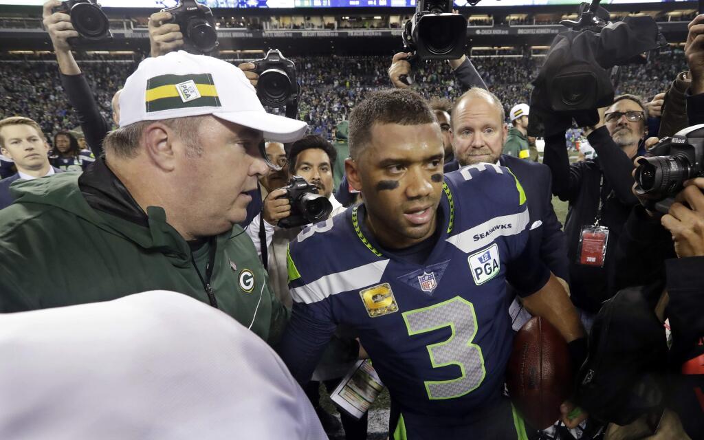 Seattle Seahawks quarterback Russell Wilson (3) talks with Green Bay Packers coach Mike McCarthy, left, following a game, Thursday, Nov. 15 in Seattle. The Seahawks won 27-24. (AP Photo/Elaine Thompson)