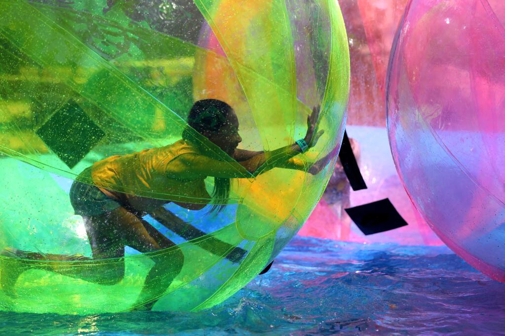 Sadie Harrington, 11, runs inside a inflatable ball floating on water at the 'Walk on Water' booth at the Sonoma County Fair in Santa Rosa on Thursday, August 1, 2019. (BETH SCHLANKER/ The Press Democrat)