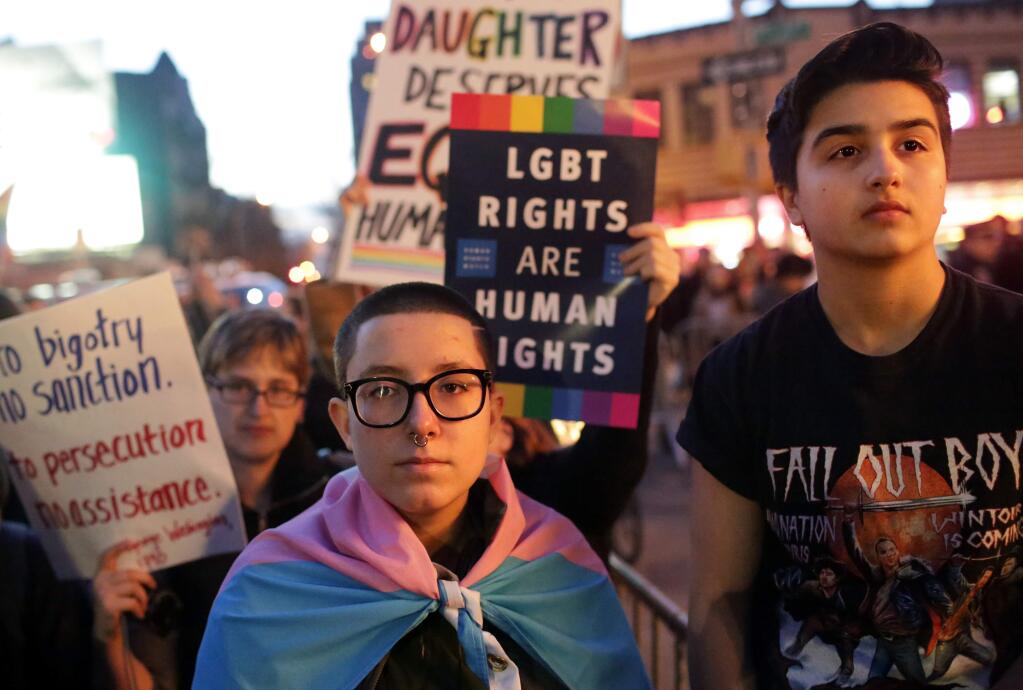 FILE -- Jasper Chagoyen, left, 15, who identifies as transgender/genderless, and Skylar Vlahakis, 16, who identifies as a transgender man, join hundreds of demonstrators outside of The Stonewall Inn in New York, Feb. 23, 2017. The demonstrators were protesting President Donald Trump's decision to rescind an Obama administration policy that protected the rights of students to use bathrooms corresponding to their gender identity this week. (Yana Paskova/The New York Times)