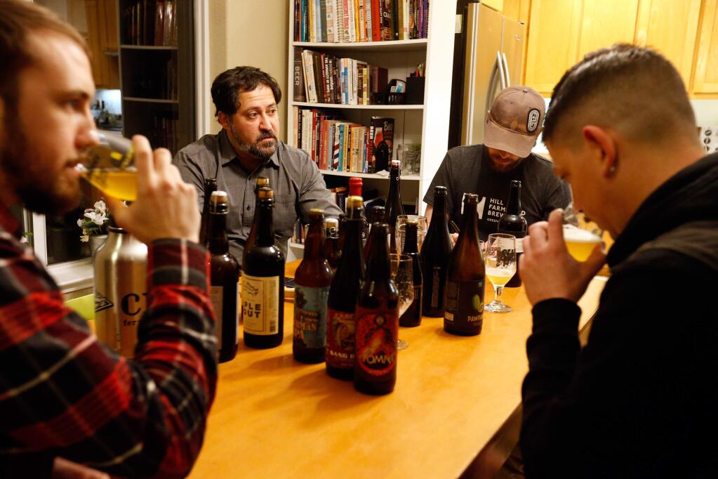 Joe Tucker, second from left, owner of the RateBeer.com website, hosts a craft beer bottle tasting at his home with Nate Barnett, left, Mike Moltchanoff, and Bobby Taul, right, in Santa Rosa, California on Wednesday, January 20, 2016. (Alvin Jornada / The Press Democrat)