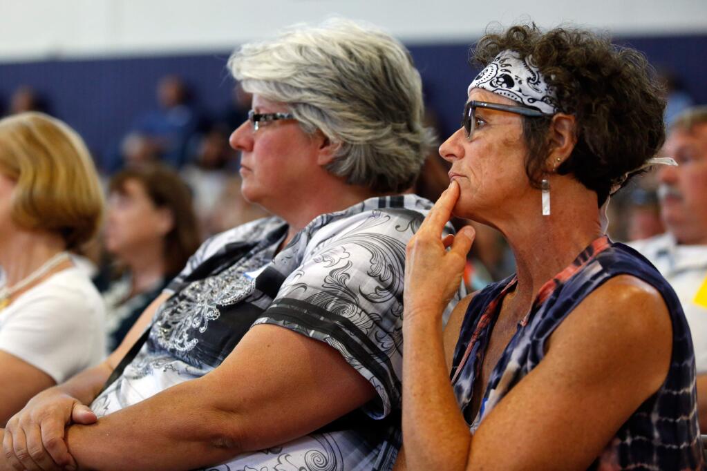 Jacquelyn Bartlett, right, of Anderson Springs and her neighbor Donna Taylor listen to county officials during a Lake County Strong Town Hall meeting at Middletown High School in Middletown, California on Thursday, June 23, 2016. (Alvin Jornada / The Press Democrat)