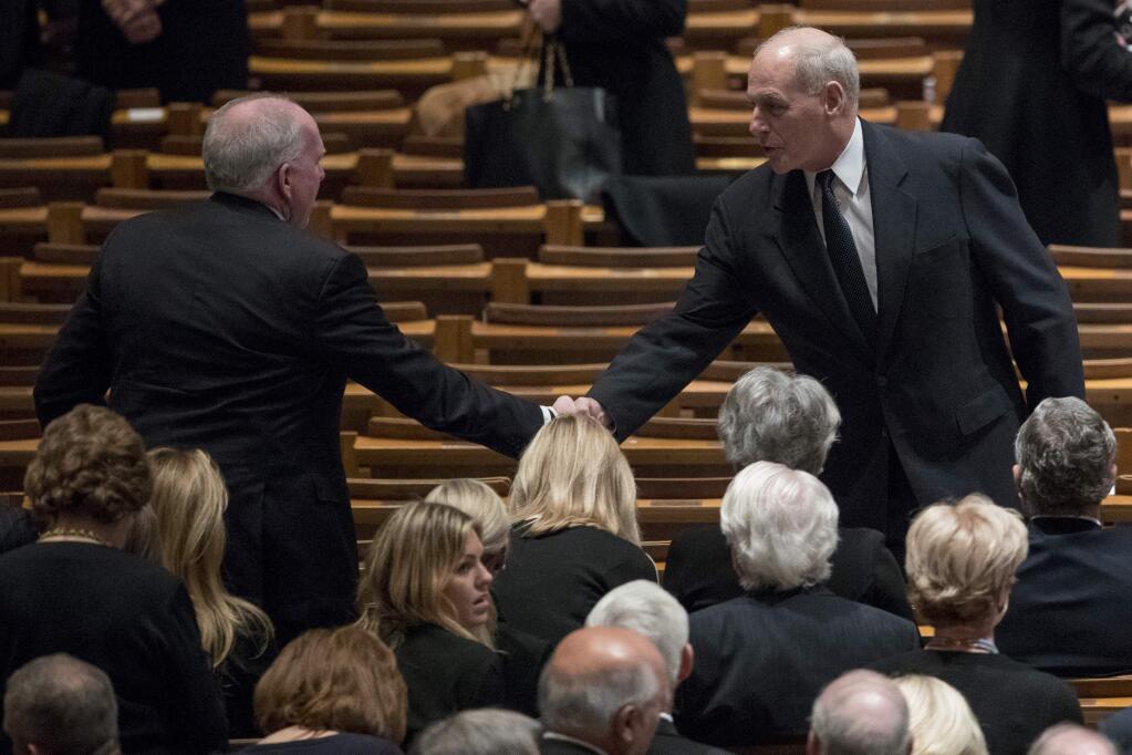 Former CIA Director John Brennan, left, shakes hands with President Donald Trump's Chief of Staff John Kelly, right, before a State Funeral for former President George H.W. Bush at the National Cathedral, Wednesday, Dec. 5, 2018, in Washington. (AP Photo/Andrew Harnik, Pool)