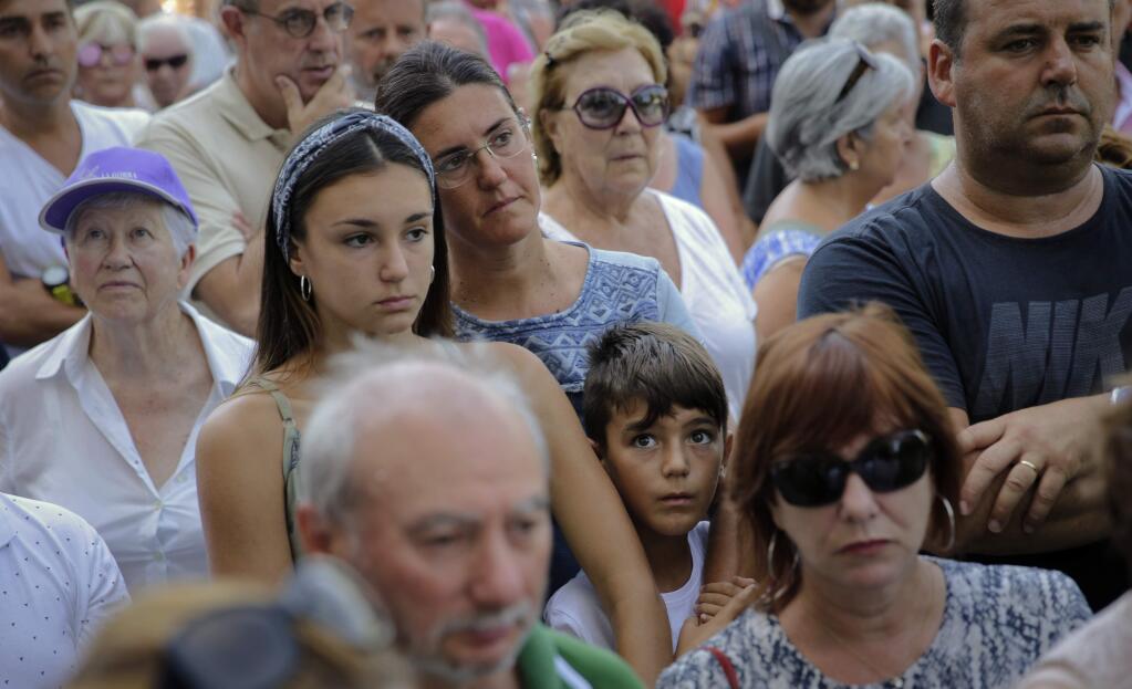 People observe a minute of silence in memory of the terror attack victims in Cambrils, Spain, Friday, Aug. 18, 2017. Spanish police on Friday shot and killed five people carrying bomb belts who were connected to the Barcelona van attack that killed at least 13, as the manhunt intensified for the perpetrators of Europe's latest rampage claimed by the Islamic State group. (AP Photo/Emilio Morenatti)