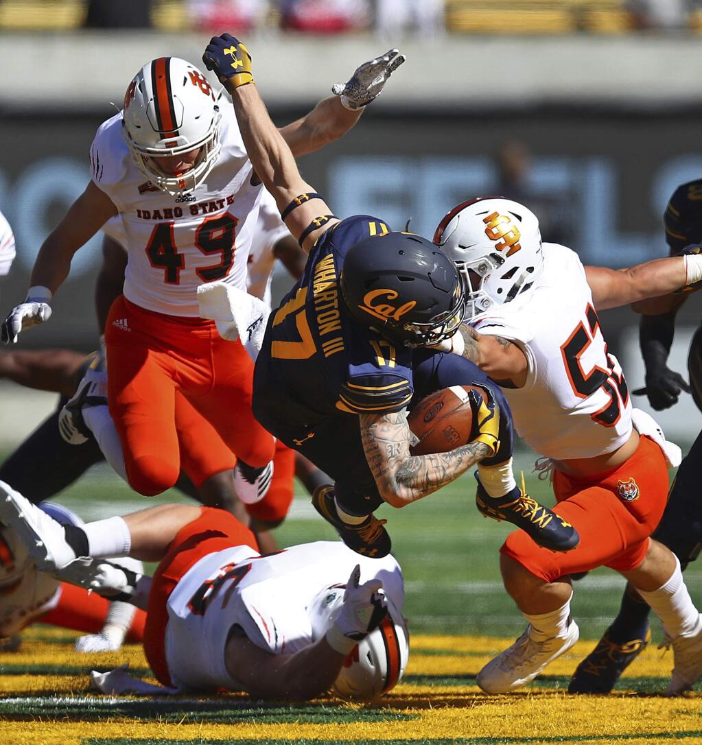 California wide receiver Vic Wharton III, center, is upended between Idaho State's Oshea Trujillo, bottom, Colton Belnap (49) and DJ Hagler, right, during the first half of an NCAA college football game Saturday, Sept. 15, 2018, in Berkeley, Calif. (AP Photo/Ben Margot)