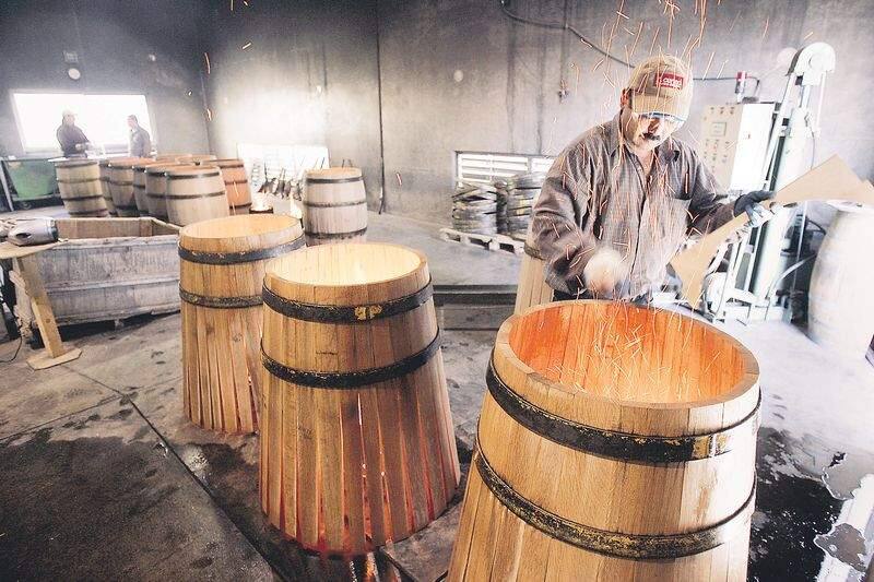 Francisco Cendejas adds wood to the fire as oak barrels are warmed in the toasting room at Tonnellerie Radoux in Santa Rosa on Thursday, January 19, 2006. (The Press Democrat/ Christopher Chung)