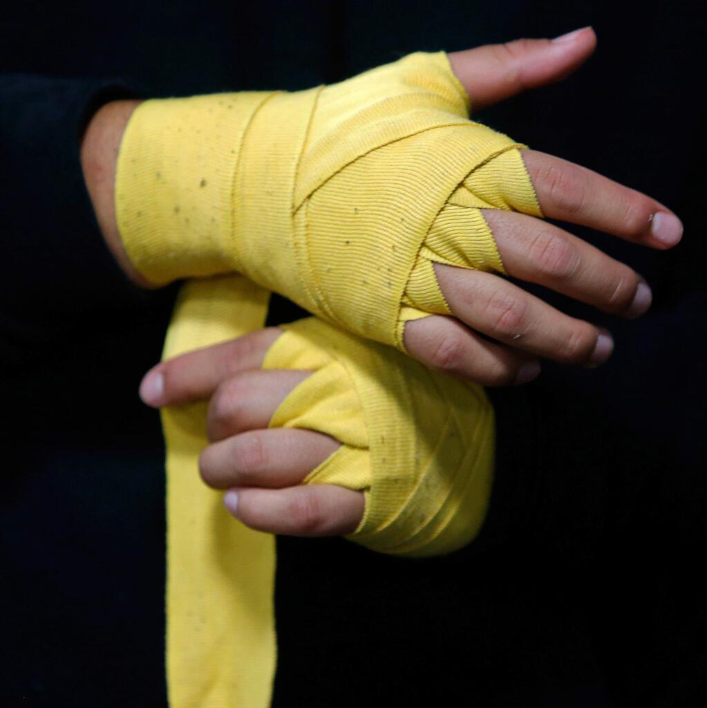 Alexis Hernandez, 15, wraps his hands for a boxing workout at Double Punches Boxing Club in Santa Rosa, California, on Tuesday, August 28, 2018. (Alvin Jornada / The Press Democrat)