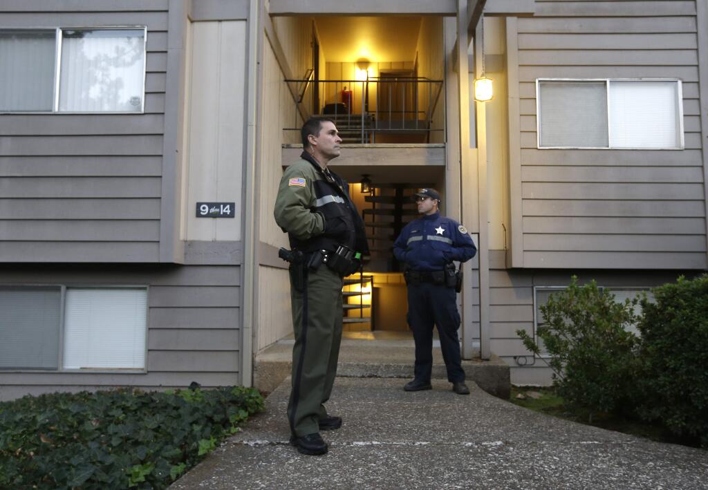 Douglas County Deputy Sheriff Greg Kennerly, left, and Oregon State Trooper Tom Willis, stand guard outside the apartment building, Friday Oct. 2 2015, where alleged Umpqua Community College gunman Chris Harper Mercer lived, in Roseburg, Ore. Armed with multiple guns, Harper, 26, walked in a writing class at the community college, Thursday, and opened fire, killing several and wounding several others. (AP Photo/Rich Pedroncelli)