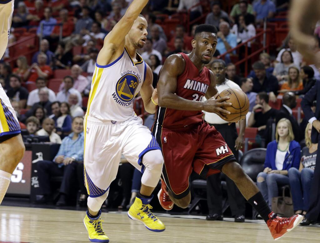 Miami Heat guard Norris Cole, right, drives to the basket as Golden State Warriors guard Stephen Curry (30) defends in the first half of a game Tuesday, Nov. 25, 2014, in Miami. (AP Photo/Lynne Sladky)
