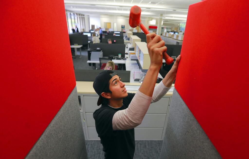 Anthony Ruiz adds panels to small glass cubicles in the renovated main building at Keysight Technologies in Santa Rosa. The measurement equipment company hauled off over 1 million pounds of debris after the October wildfires. (photo by John Burgess/The Press Democrat)